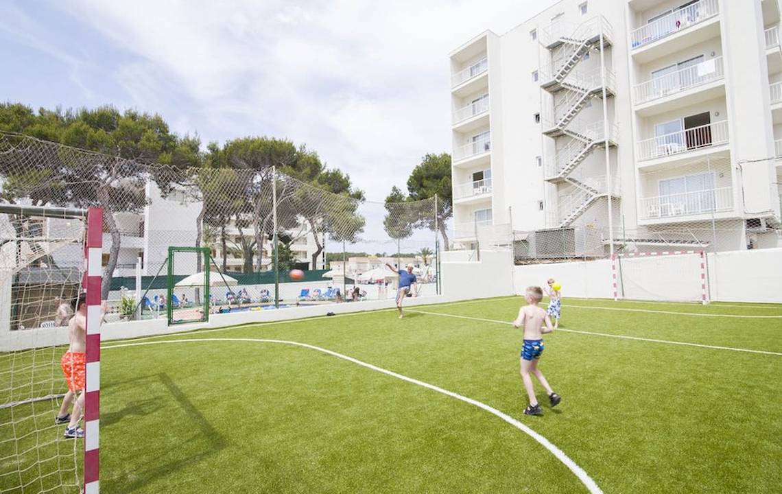 Kinder spielen Fußball auf einem Kunstrasenplatz im Moon Dreams Coral Beach Hotel.