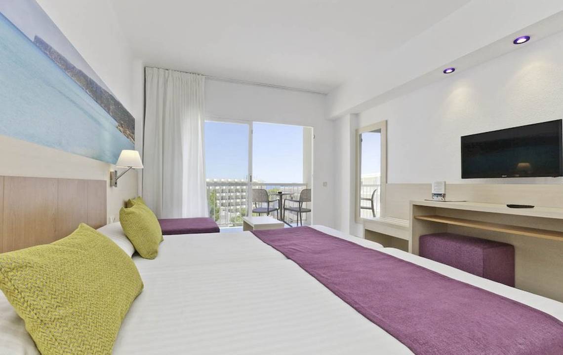 Helle Hotelzimmer im Moon Dreams Coral Beach mit zwei Betten, Balkon und moderner Einrichtung.