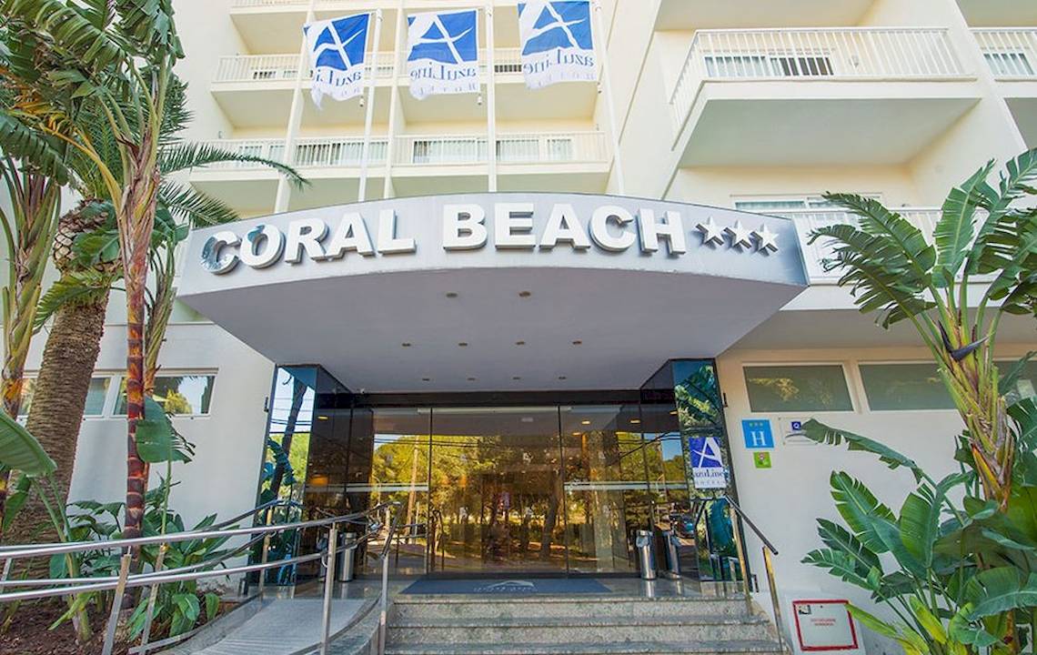 Eingang des Hotels Moon Dreams Coral Beach mit modernen Elementen und tropischer Vegetation.