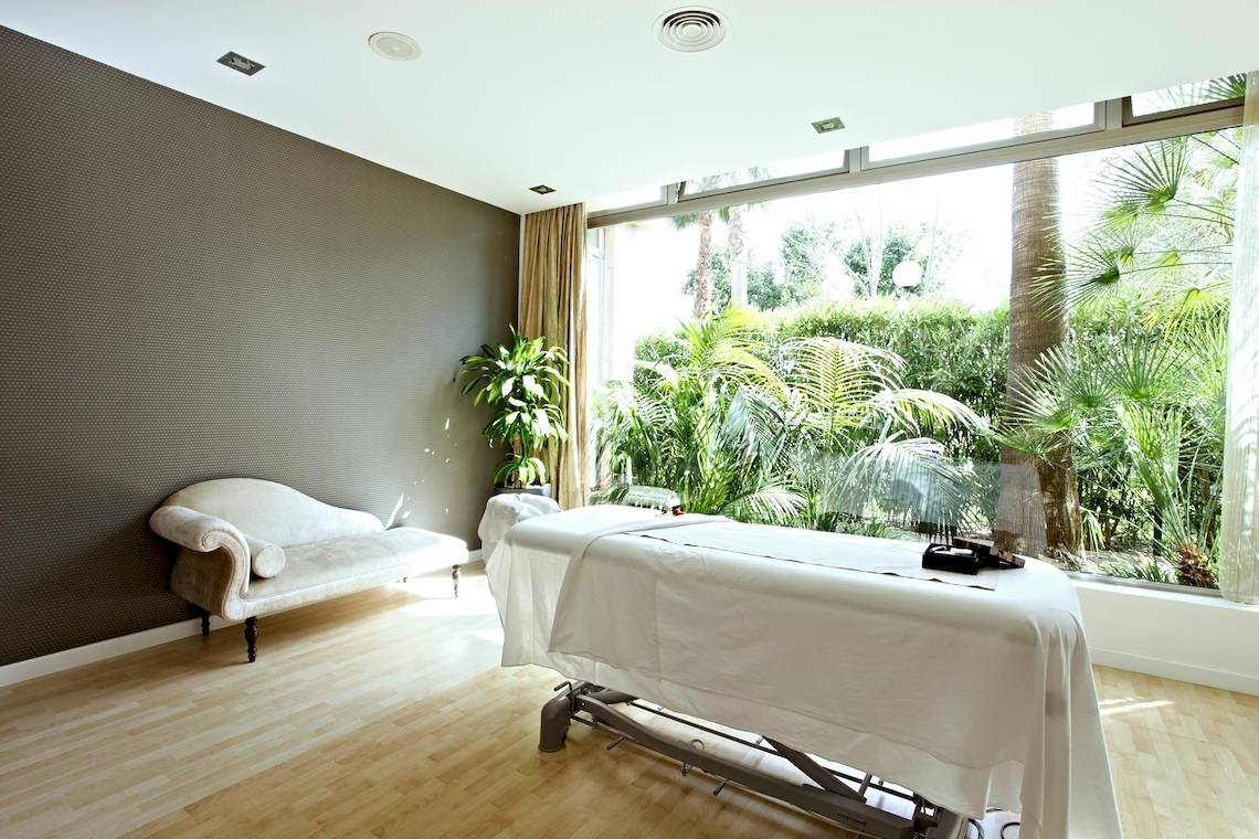 Massageraum im Zafiro Tropic Hotel mit Blick auf tropische Pflanzen.