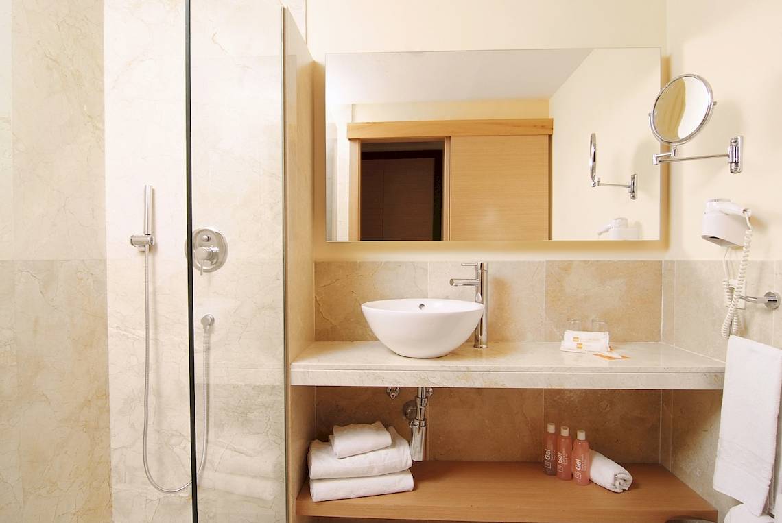 Badezimmer des Zafiro Tropic Hotels mit einer großen Spiegel und einer weißen Badewanne.