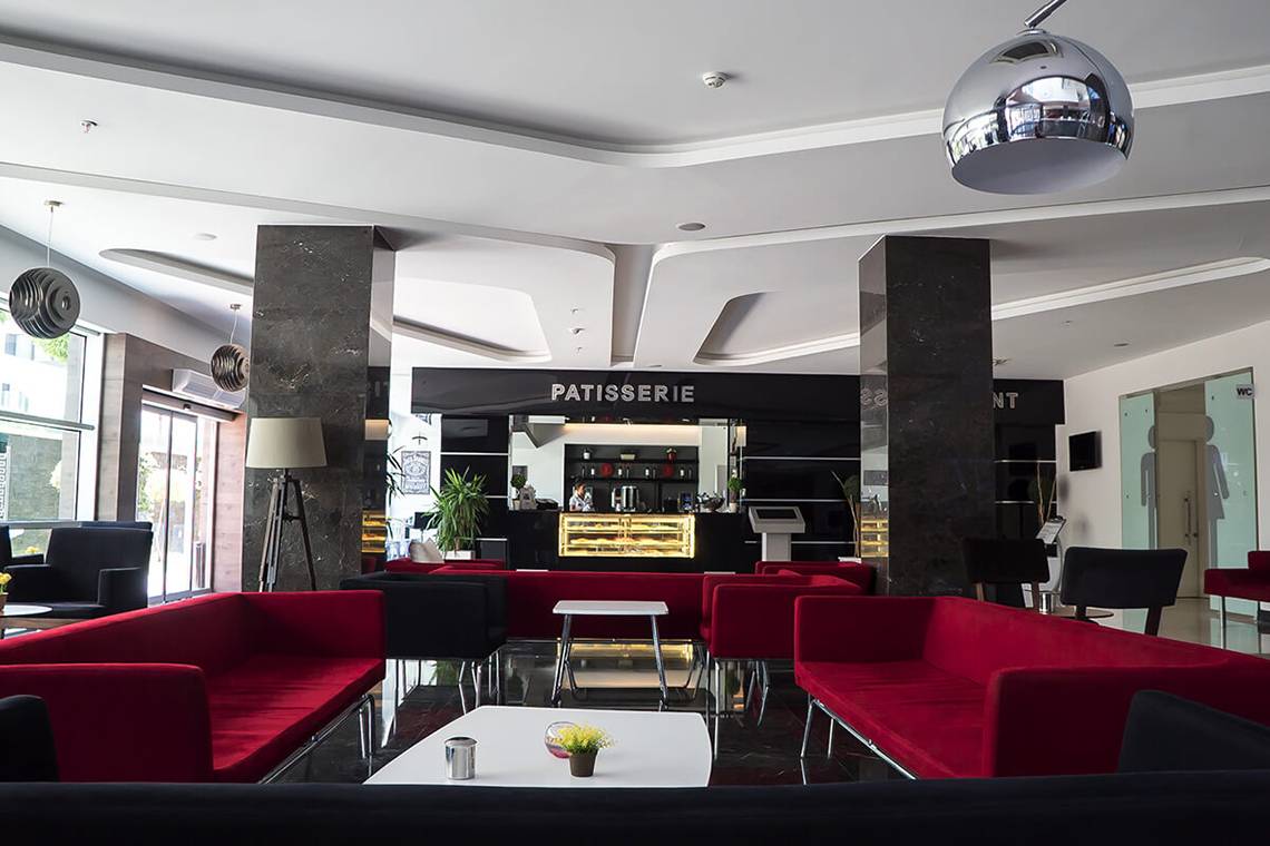 Lobby des White City Resort Hotels mit roten Sofas und einer modernen Einrichtung.