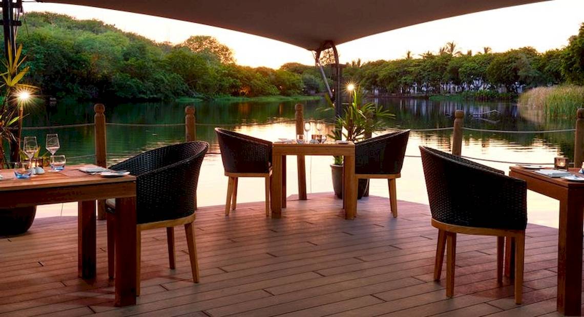 Außenterrasse des Ravenala Attitude Hotels mit Blick auf einen See