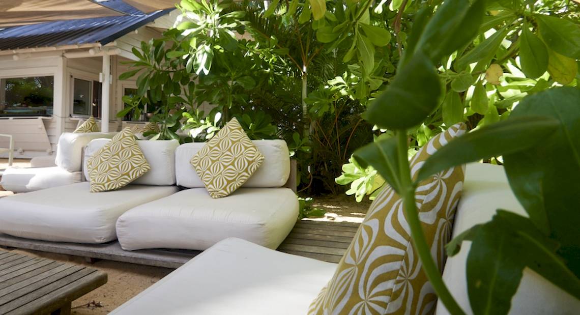 Loungebereich des The Ravenala Attitude Hotels mit weißen Möbeln und grünen Pflanzen.