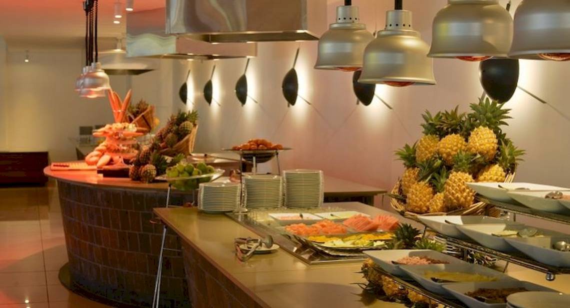 Buffettisch im Ravenala Attitude Hotel mit verschiedenen Früchten und Gerichten.