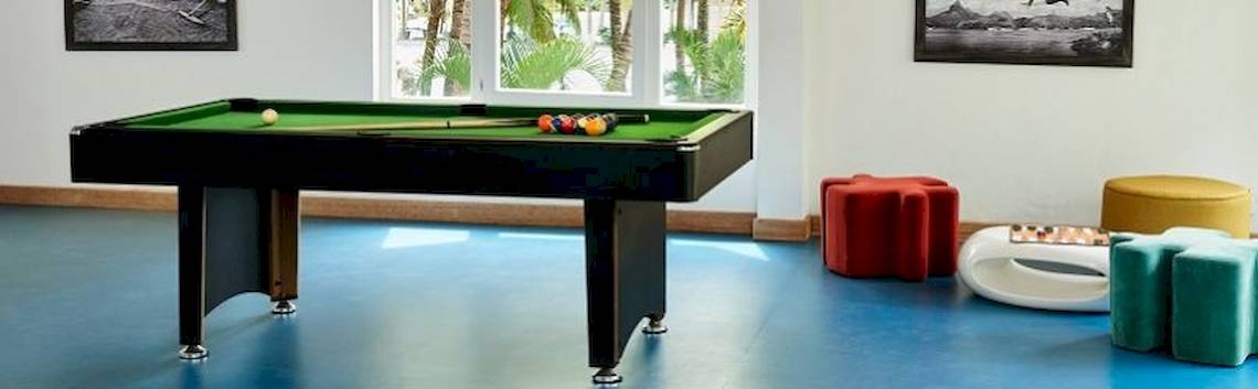 Pooltisch im Hotelraum von The Ravenala Attitude mit bunten Stühlen und Gemälden an der Wand.