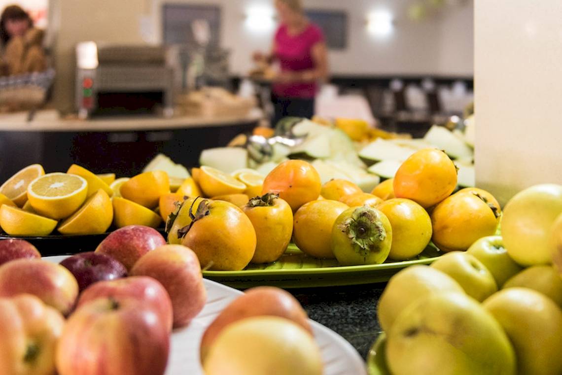 Früchte-Buffet im Lanzarote Village Hotel mit verschiedenen Obstsorten wie Äpfeln, Orangen und Persimonen.