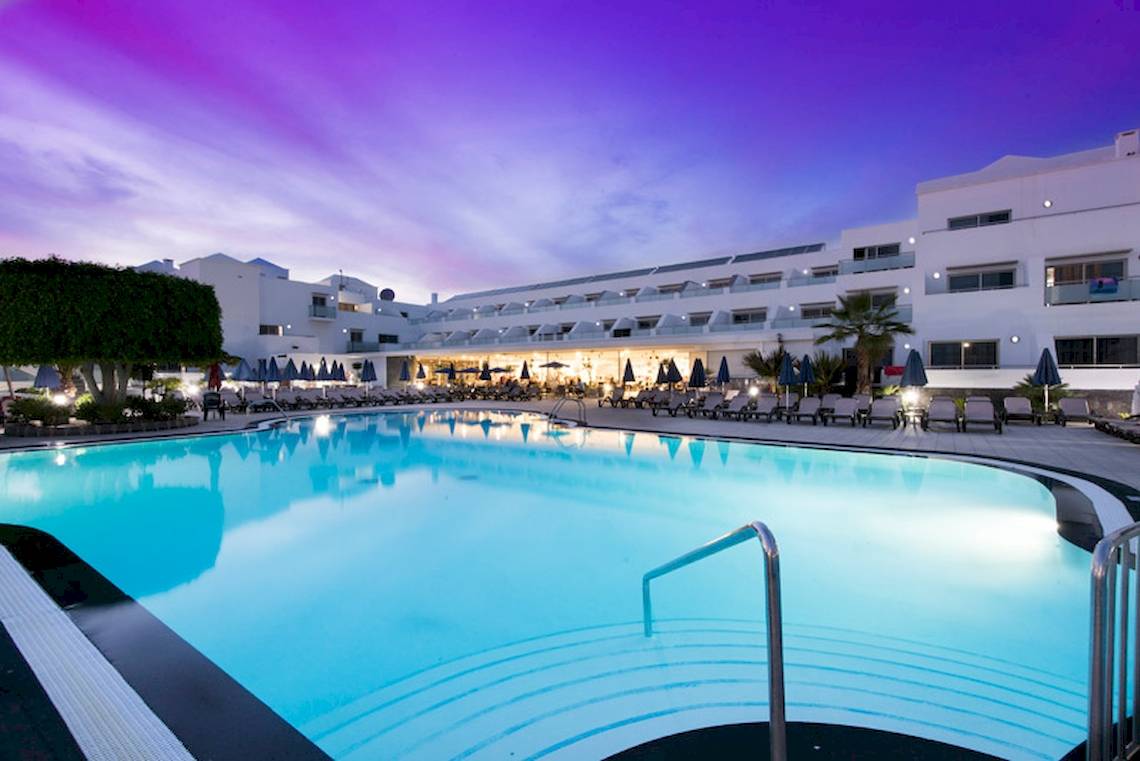 Abendansicht des Swimmingpools im Lanzarote Village Hotel mit leuchtender Beleuchtung.