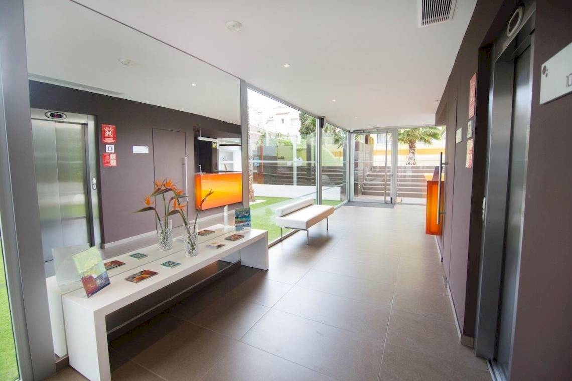 Hotellobby-Eingang mit Empfangstresen und Blumen, Ibiza Sun Apartments