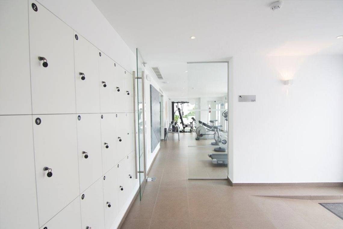 Innenansicht eines Fitnesscenters mit Spinden und Trainingsgeräten