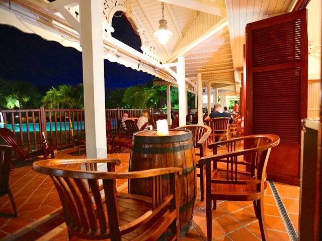 Terrasse im Hotel Pierre & Vacances Village Sainte Luce mit Sitzgelegenheiten und Pool im Hintergrund.