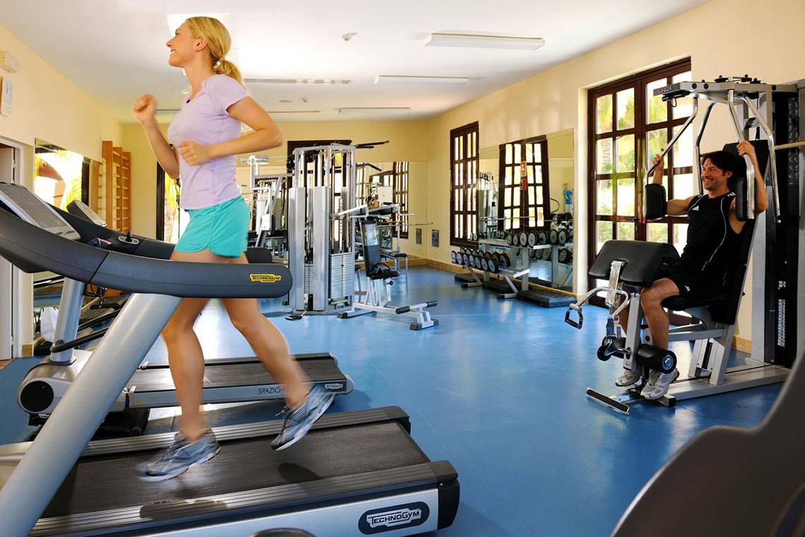Fitnessstudio im Hotel Iberostar Playa Alameda mit Frau auf dem Laufband und Mann an der Maschine.