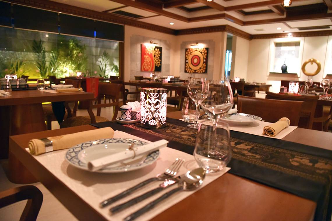 Ein Tisch im Restaurant Kurumba Maldives mit Geschirr und Tischdekoration.