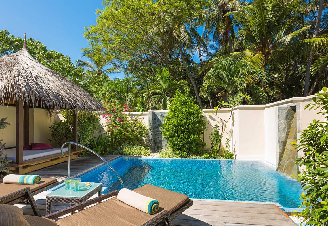 Poolbereich im Kurumba Maldives mit Hütte und Pflanzen