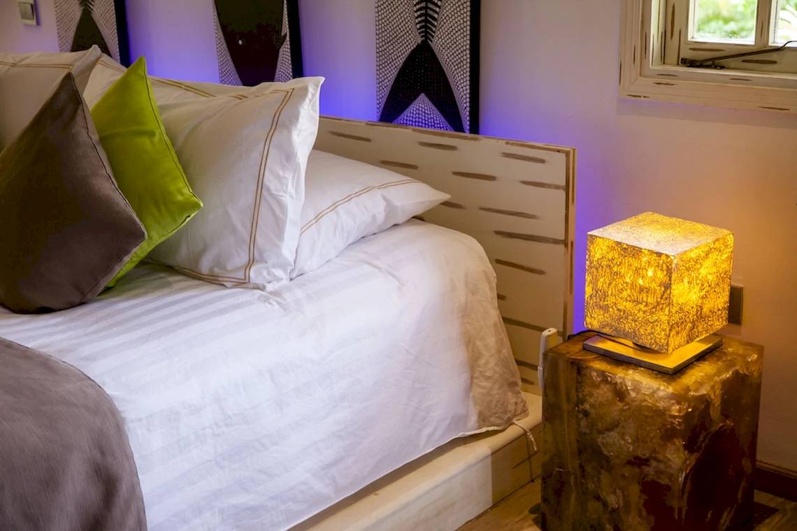 Bett im Le Domaine de L'Orangeraie Resort & Spa mit Kissen und Lampe