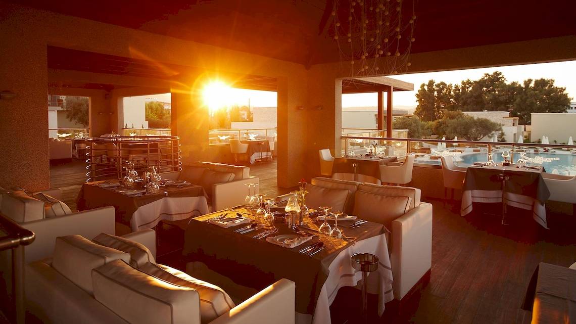 Sonnenuntergang im Port Royal Restaurant mit Blick auf den Pool und beleuchteten Tischen.