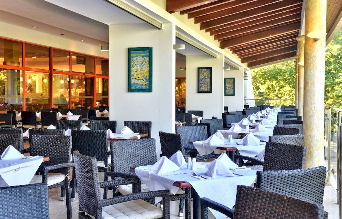 Restaurantterrasse im Kaliakra Beach Hotel mit gedeckten Tischen und Stühlen.
