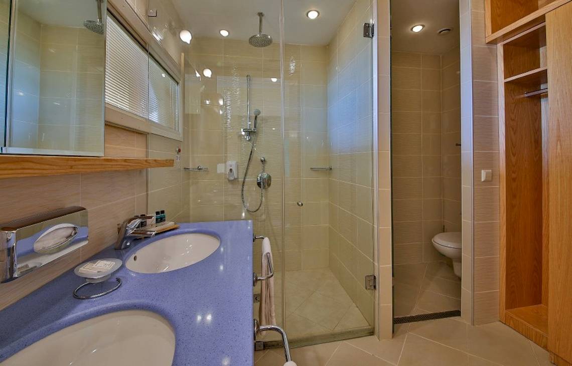 Badezimmer im Kaliakra Beach Hotel mit blauem Waschbecken, Dusche und Toilette.