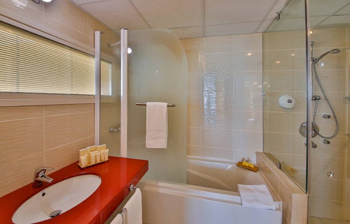 Badezimmer im Kaliakra Beach Hotel mit Badewanne, Dusche und Waschbecken.
