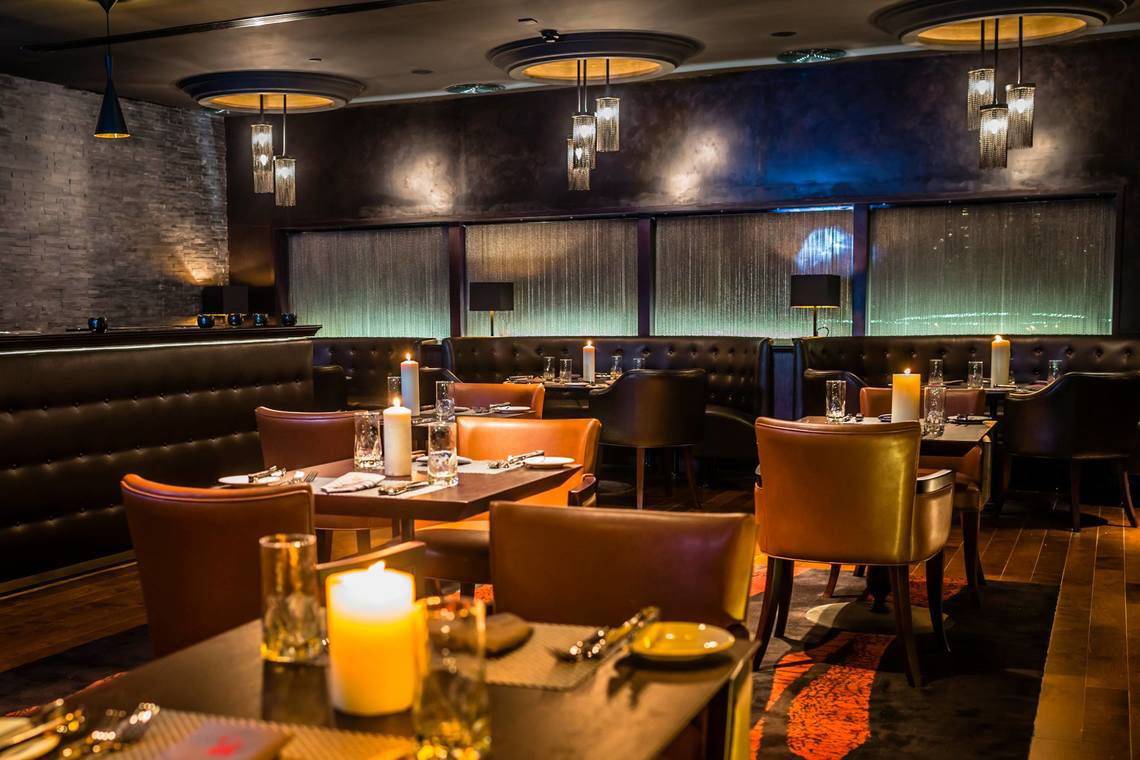 Innenbereich des Millennium Plaza Downtown Hotels mit gedämpften Lichtern und Kerzen auf den Tischen.