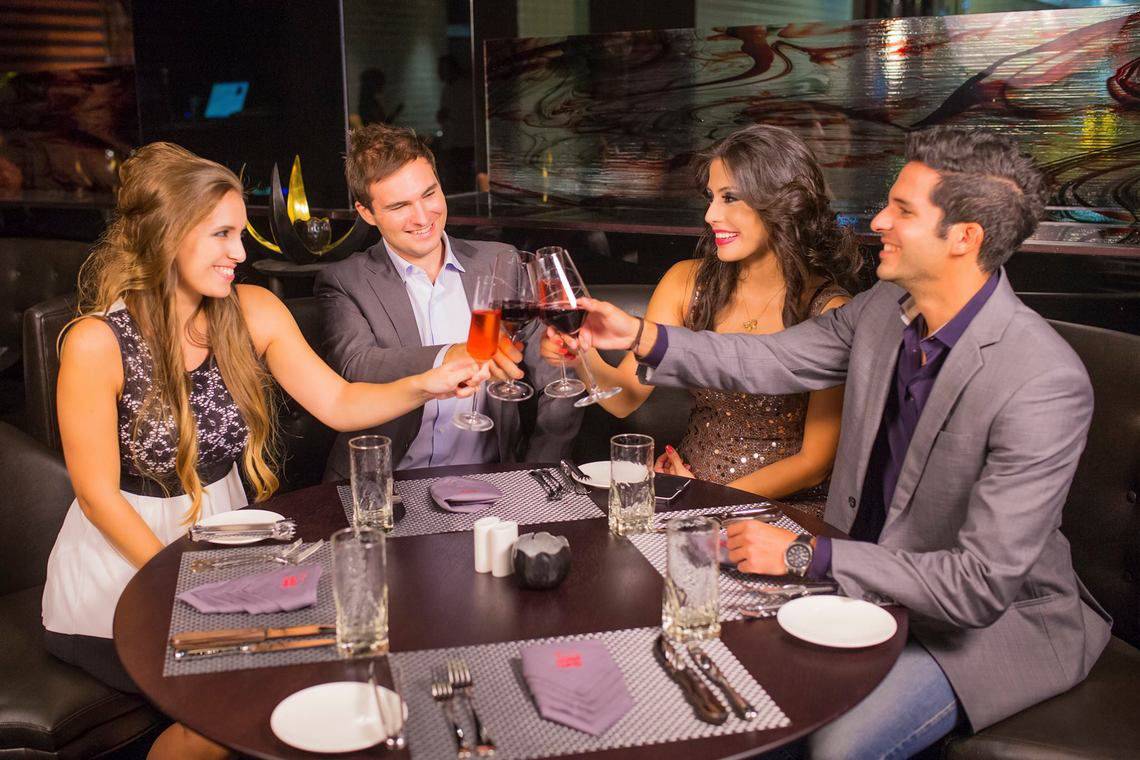 Gruppe von Leuten, die im Restaurant mit Rotwein anstoßen