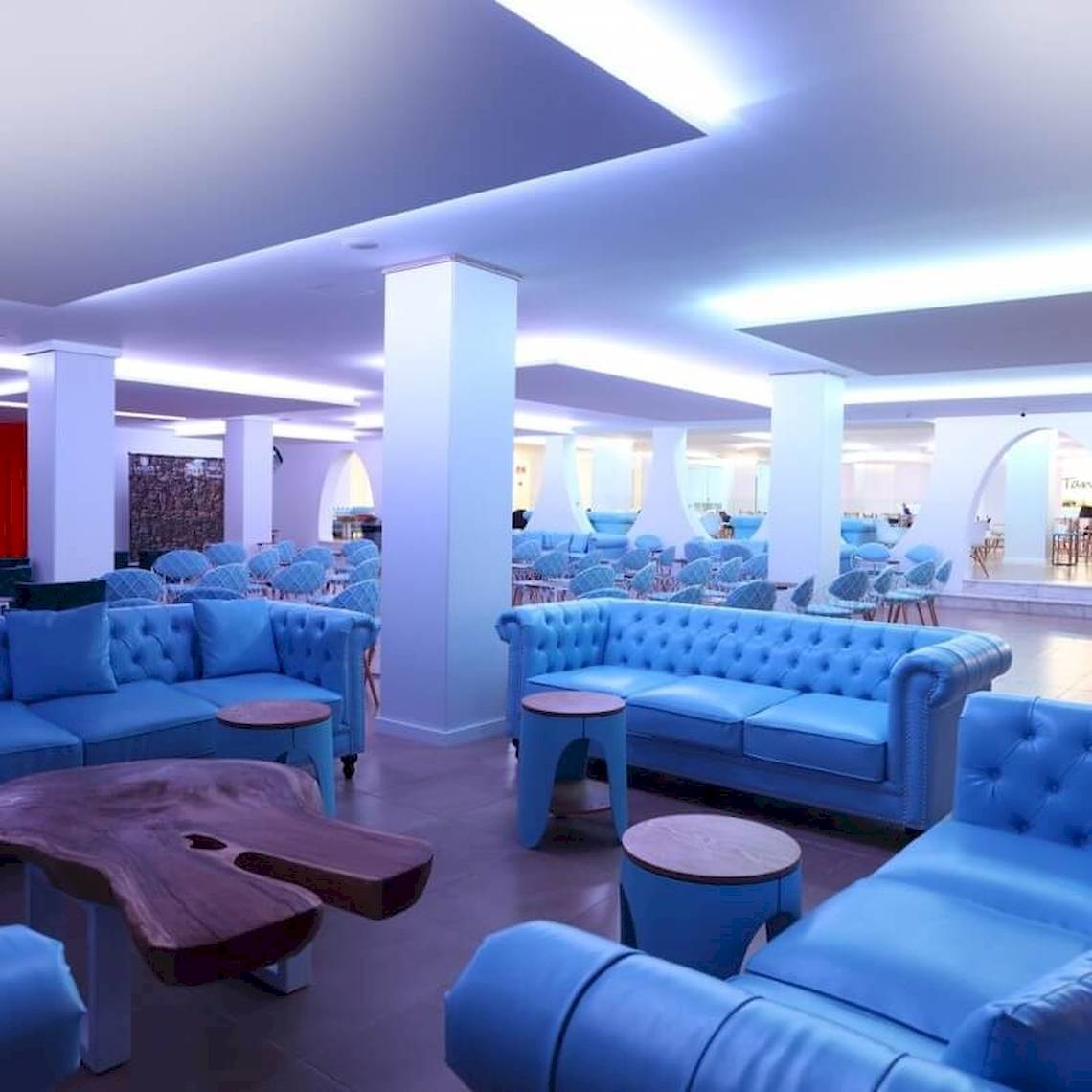 Innenbereich des Sandos El Greco Beach Hotels mit blauen Sofas und Tischen