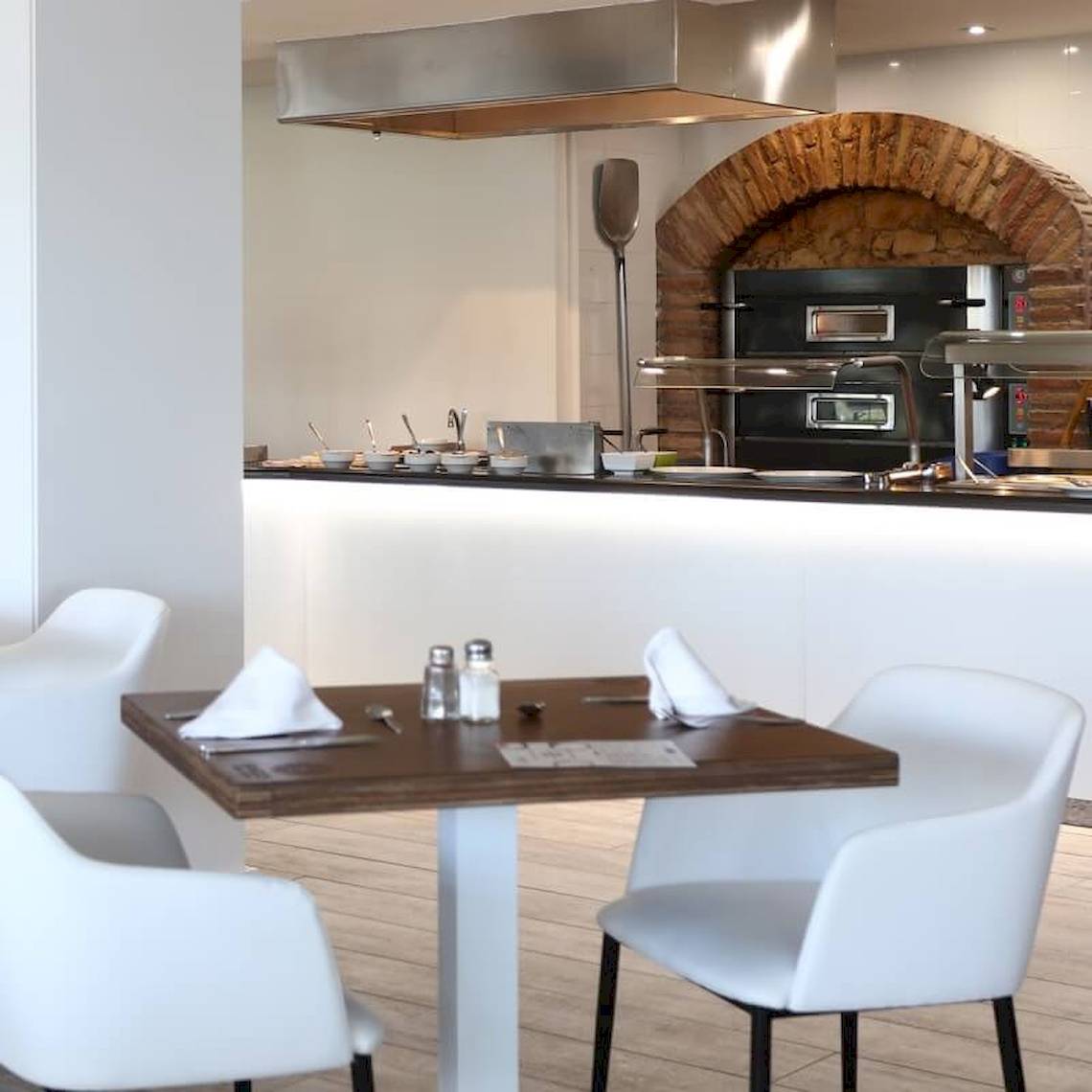 Innenbereich des Sandos El Greco Beach Hotels mit Tisch, Stühlen und Kochbereich
