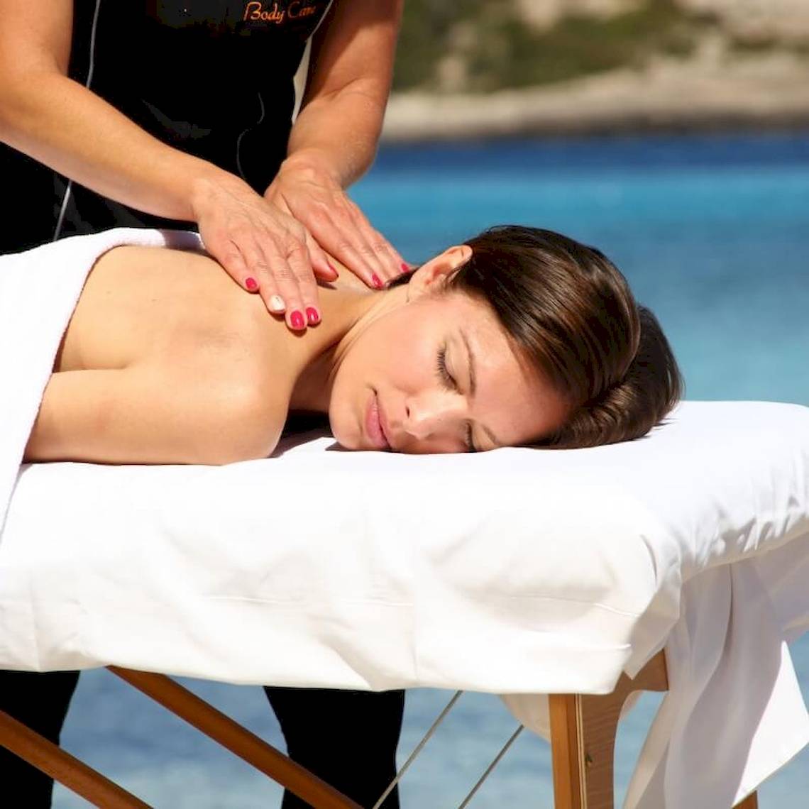 Frau genießt eine Massage am Strand im Sandos El Greco Beach Hotel