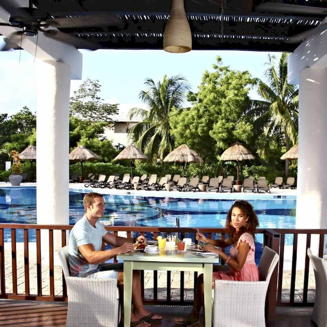 Paar beim Essen am Pool im Sandos Caracol Eco Resort