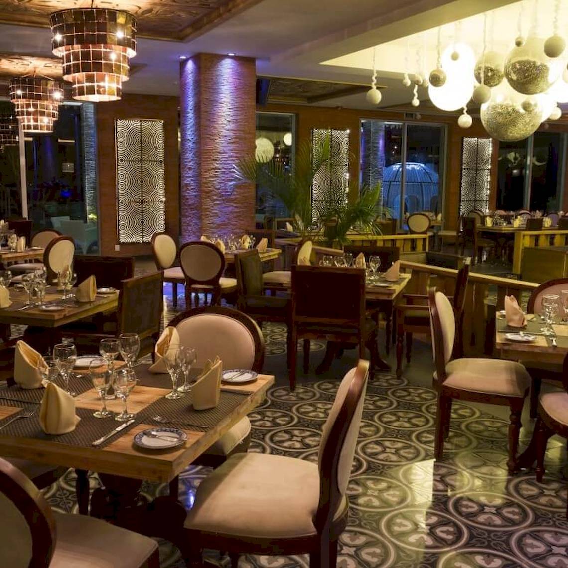 Restaurant des Sandos Caracol Eco Resort mit gedeckten Tischen und dekorativen Lampen.