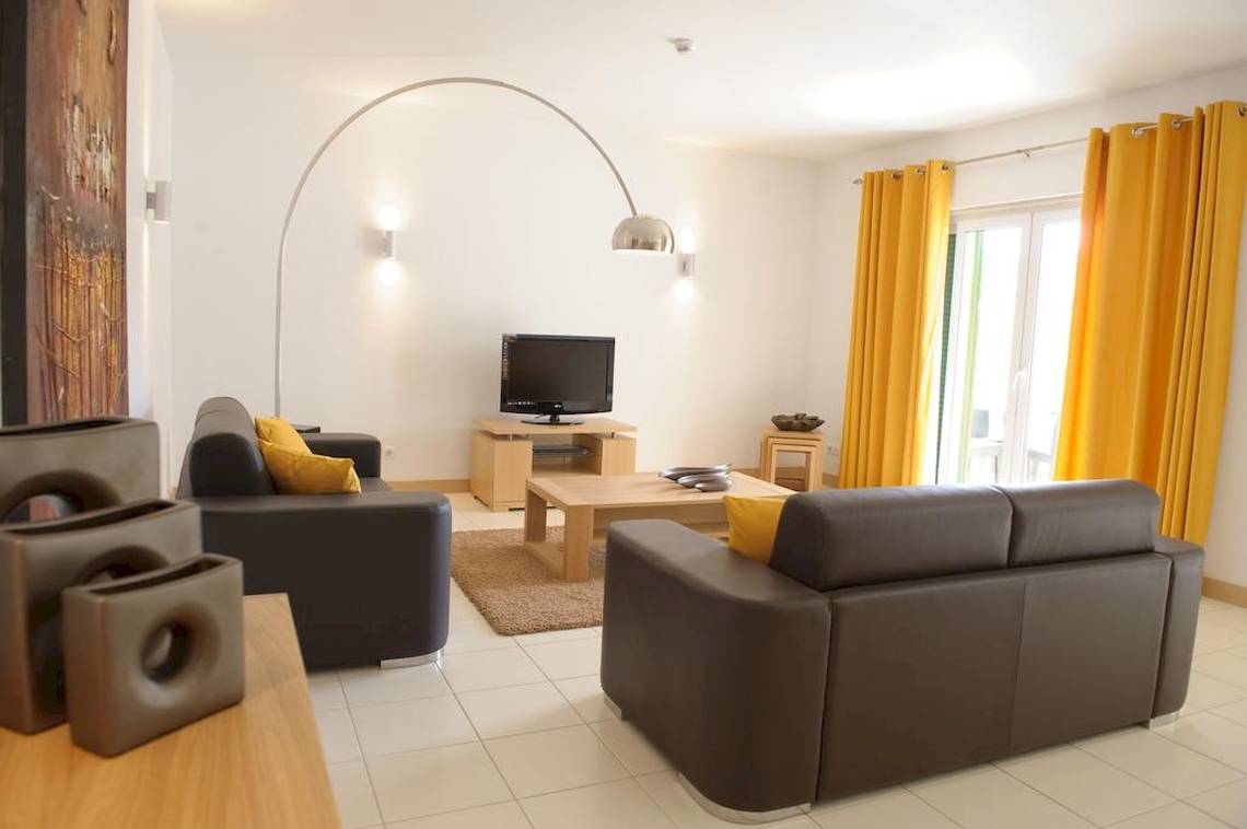 Wohnzimmer im Agua Hotels Sal Vila Verde mit zwei Sofas, Couchtisch und Fernseher.