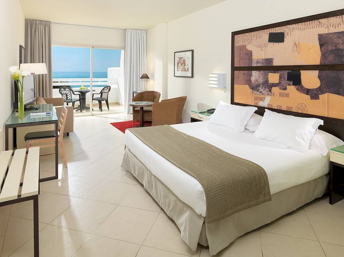 H10 Estepona Palace Hotel Zimmer mit Meerblick, modernen Möbeln und Komforteinrichtungen.