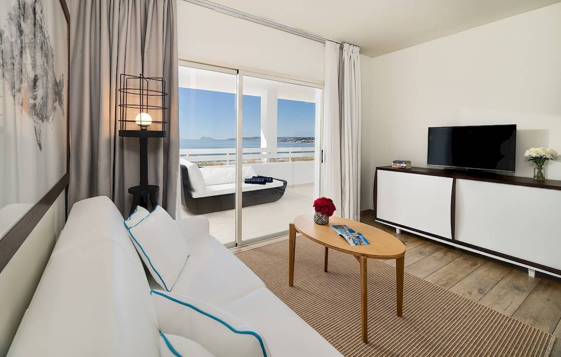 Wohnzimmer im H10 Estepona Palace mit Blick auf das Meer und eine Terrasse.