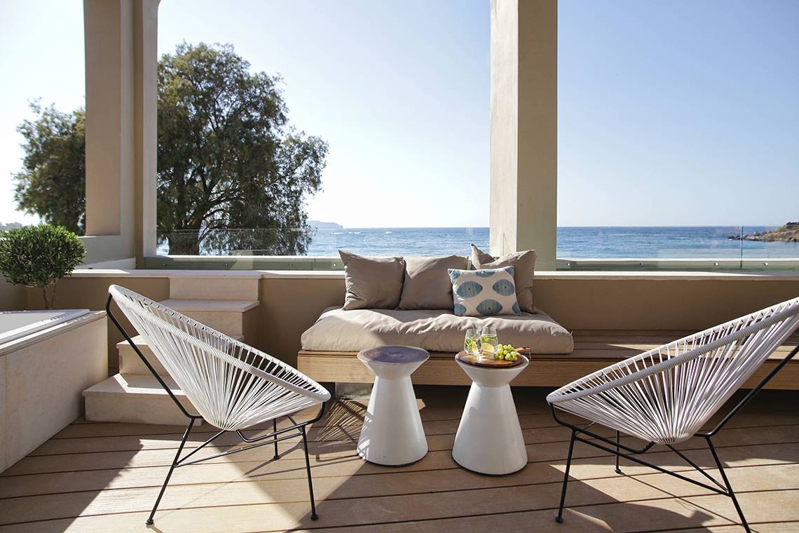 Terrasse des Domes Noruz Chania, Autograph Collection mit Blick auf das Meer und zwei weißen Stühlen.