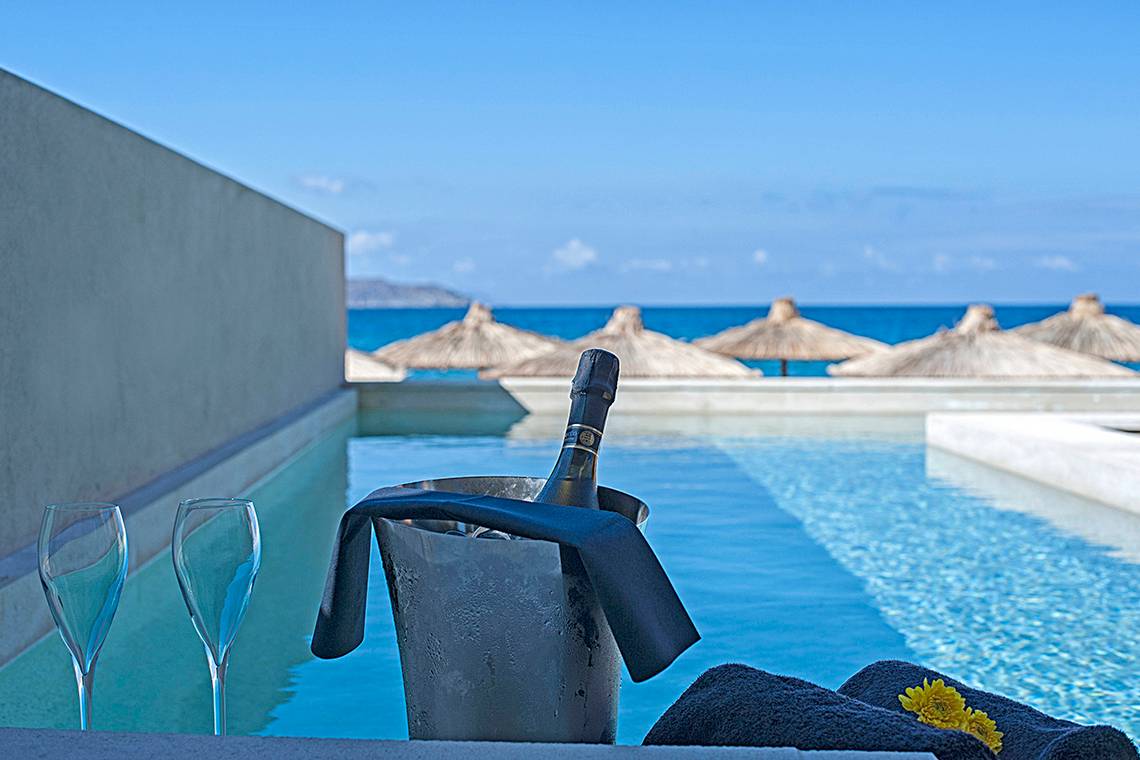 Pool mit Champagner und Handtuch im Domes Noruz Chania