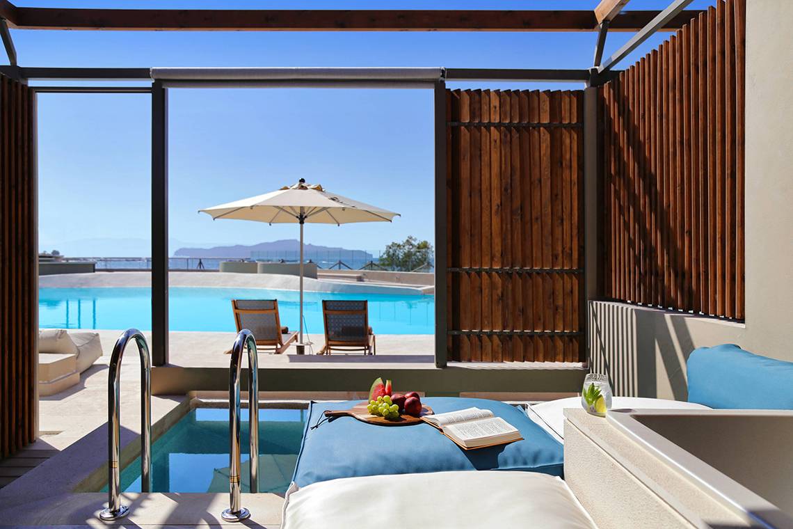 Suite mit Blick auf den Pool und Sonnenschirm im Domes Noruz Chania