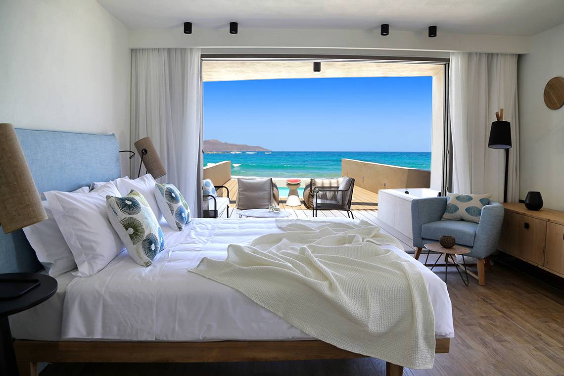 Schlafzimmer mit Meerblick im Domes Noruz Chania Hotel, mit einem großen Bett und einer Terrasse, die auf das Meer hinausblickt.