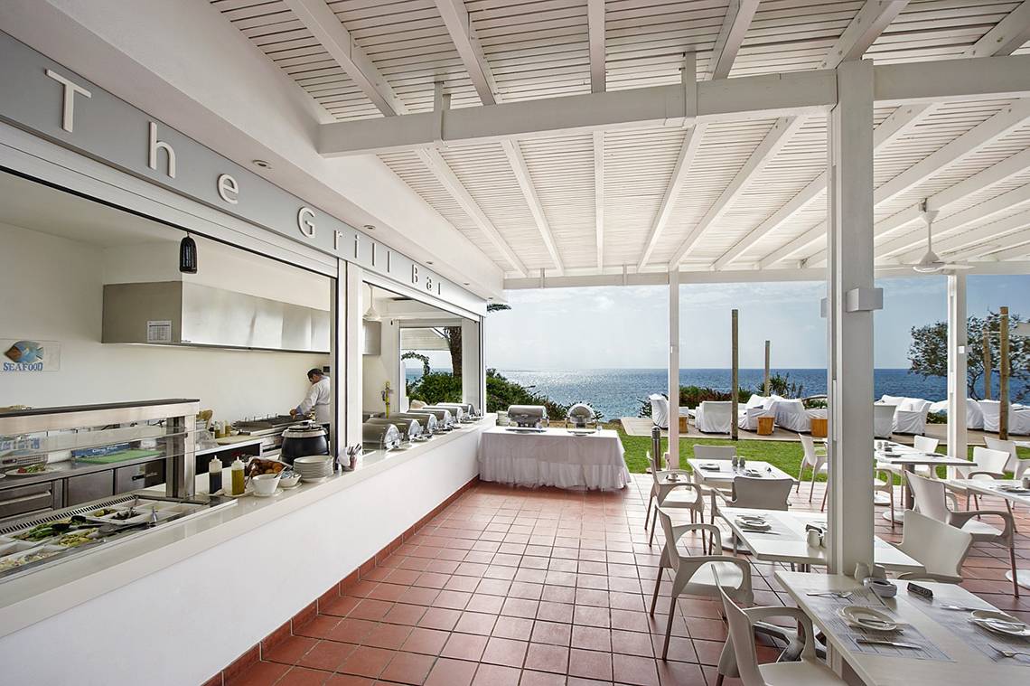 Grillbar im Freien des Grecian Sands Hotels mit Blick auf das Meer.