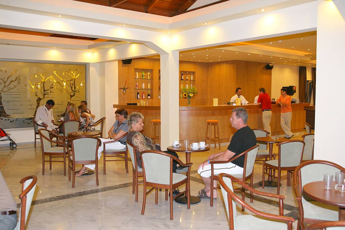 Foto des Innenbereichs des Europa Beach Hotel & Spa mit Gästen an Tischen und einer Bar.