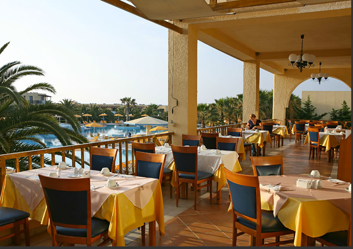Restaurantterrasse im Porto Bello Beach Hotel mit Blick auf den Pool.