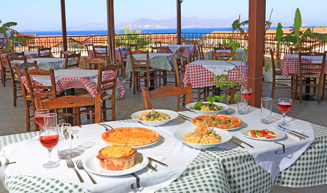 Terrassen-Restaurant des LABRANDA Marine Aquapark Hotels mit mehreren gedeckten Tischen und Blick auf das Meer.