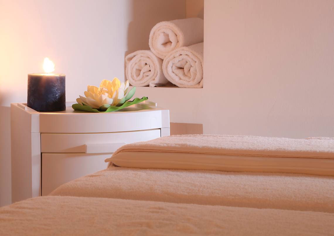 Spa-Bereich im LABRANDA Marine Aquapark mit einem Bett, einer Kerze und Blumen.