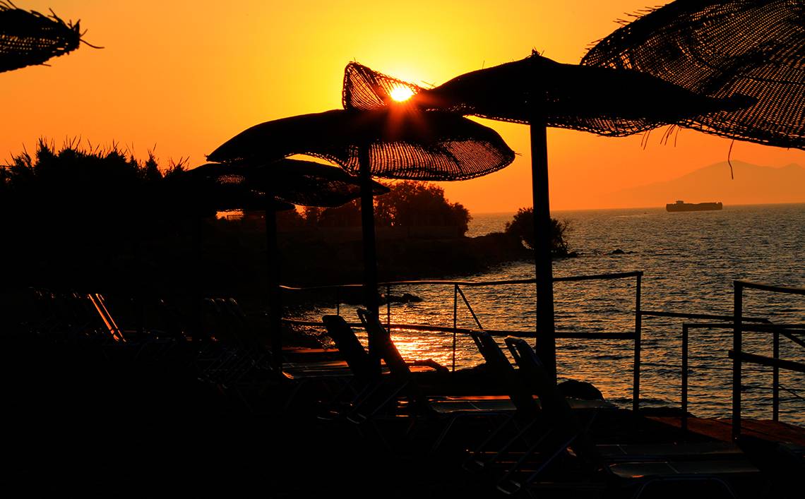 Abendstimmung am Strand des LABRANDA Marine Aquapark mit Sonnenuntergang und Sonnenschirmen.