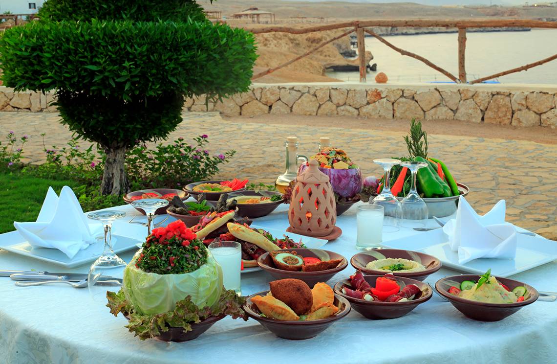 Essen auf einem Tisch im Freien mit Blick auf das Meer im Sharm Club Beach Resort