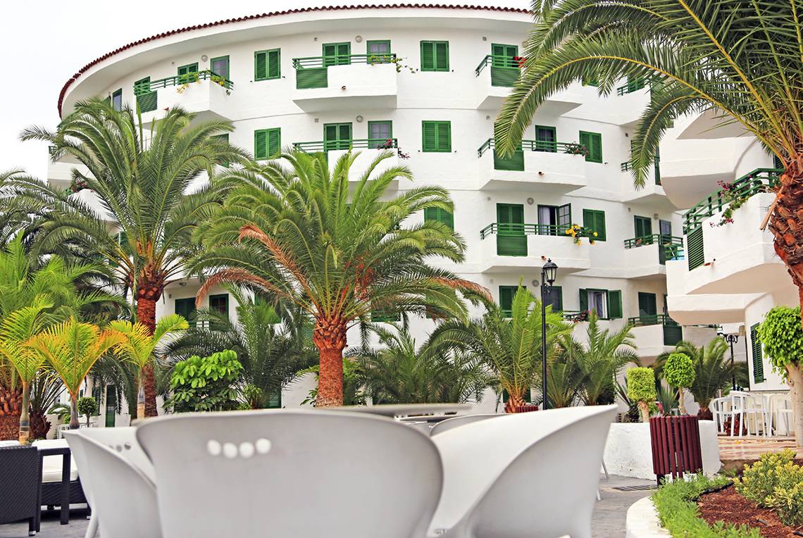 Foto von der Terrasse des LABRANDA Playa Bonita Hotels mit weißen Stühlen und Palmen.
