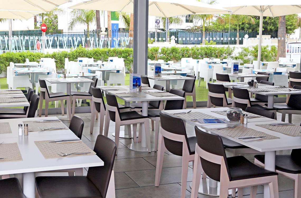 Restaurant im Freien des LABRANDA Playa Bonita Hotels mit weißen Tischen und Stühlen unter großen Schirmen.