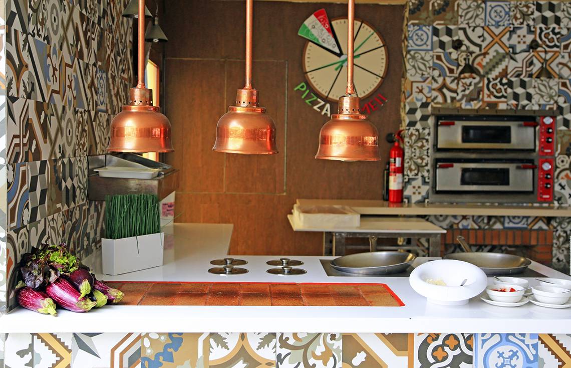 Innenansicht der Pizzaherstellung im LABRANDA Playa Bonita Hotel mit Küchenutensilien und dekorativen Elementen.