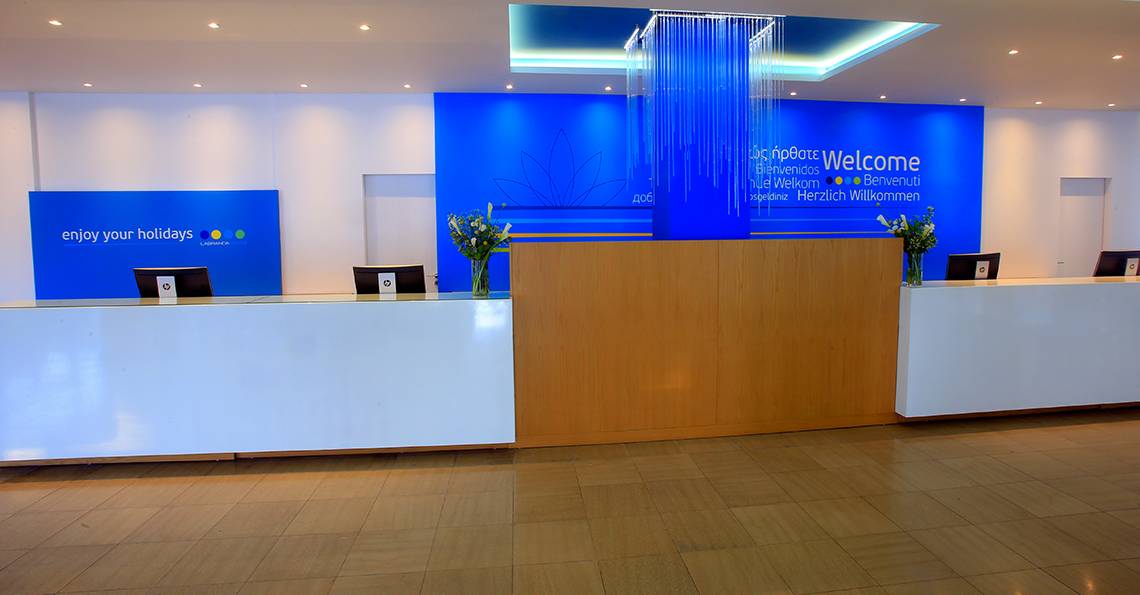 Empfangsbereich des Labranda Kiotari Miraluna Resorts mit blauer Wand und Willkommensschild.