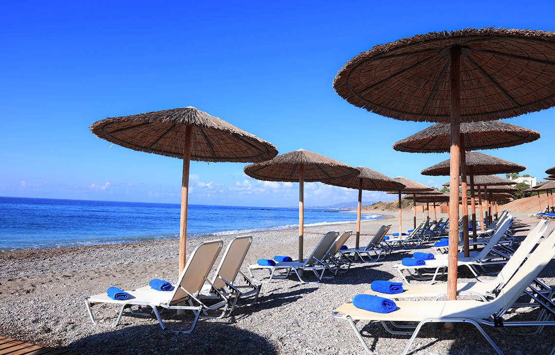 Strand des Labranda Kiotari Miraluna Resorts mit Sonnenschirmen und Liegestühlen