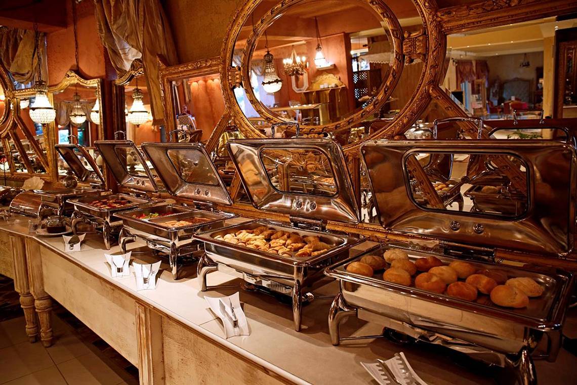 Buffet-Tisch im Orpheas Resort mit verschiedenen Speisen in silbernen Schalen.